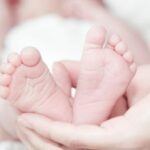 Baby feet held by adult hand- featured image for Rare unisex baby names ideas